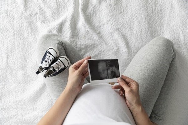 Беременная женщина рассматривает снимок УЗИ