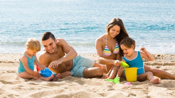 На фото – родители с детьми на пляже