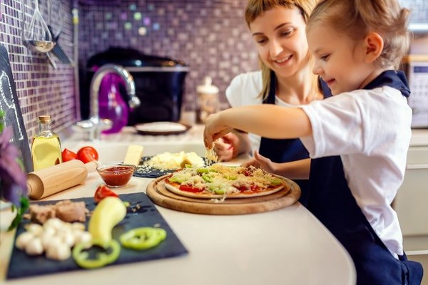 На фото – мама с ребенком готовят пиццу