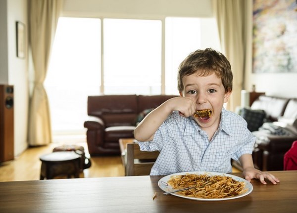 На фото – мальчик ест спагетти